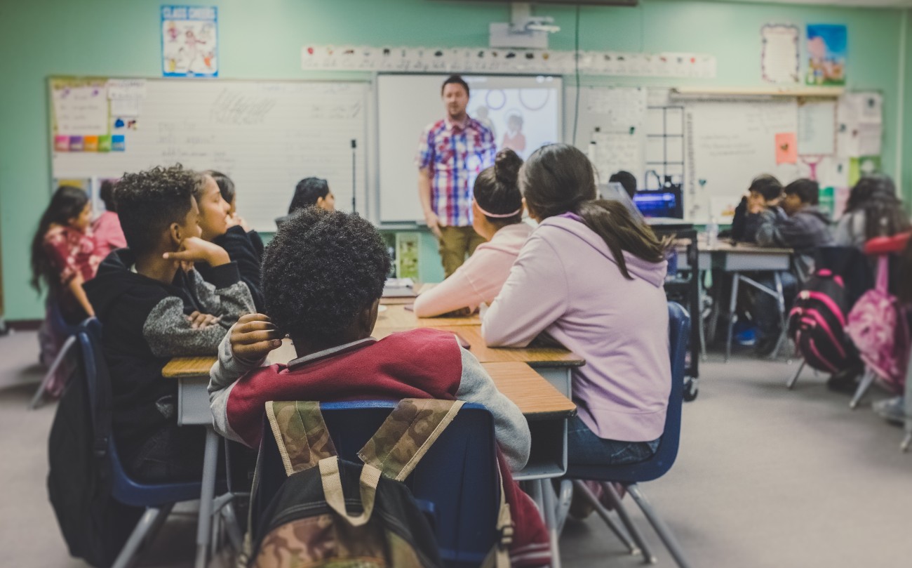 students in classroom looking at their teacher