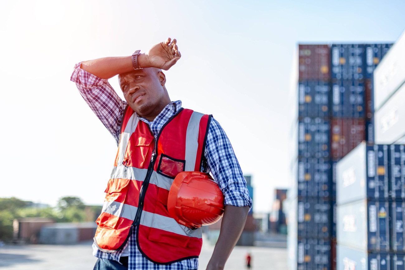 worker wiping sweat from his brow